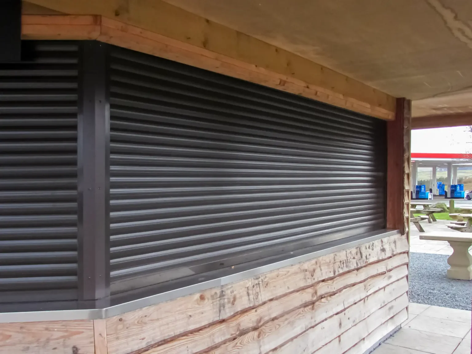 Dark brown Callisto aluminium continental roller shutters fitted to a kiosk at a service station